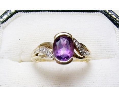 A 9 carat gold ring set amethyst on diamond set shoulders