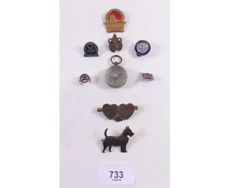 A small group of badges and a pocket compass 