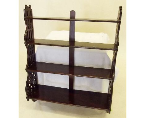 An Edwardian mahogany four tier wall display shelf with pierced sides