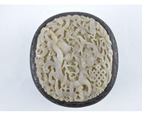 A 19th century chinese hardwood box and cover, the sides carved with flowers and having a inset celedon jade plaque to lid de