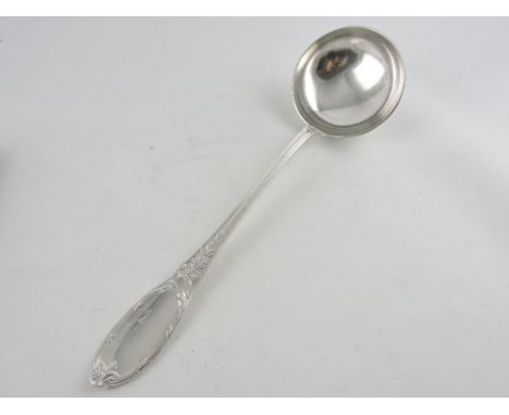 A large Christofle silver plated soup ladle with circular bowl, reeded stem and leaf chased terminal