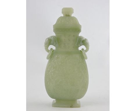 A early 20th century Chinese celedon jade urn and cover, with twin elephant head handles and floral carving to body. H 21cm