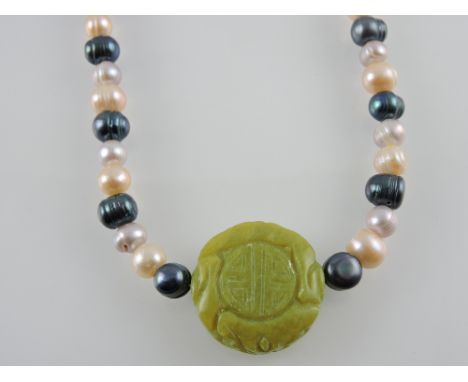 A necklace of grey, pink and cream freshwater pearls the centre carved with Korean jade medallion