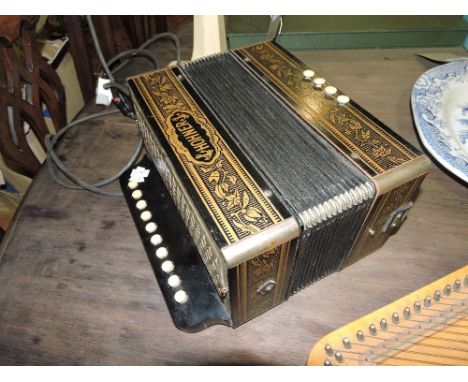 A Hohner accordion embellished with bands of gilt flowers and leaves and with leather straps
