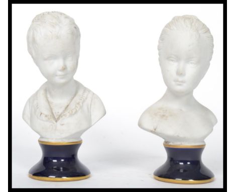 A pair of Unter Weiss Bach 1882 ceramic bust figurines of children - girl and boy raised on cobalt ceramic bases. Stamped to 