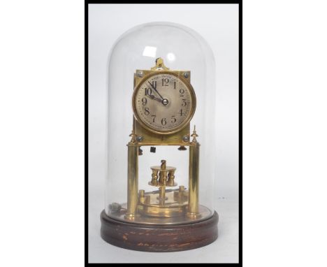 Gustav Becker - A perpetual brass anniversary clock having a glass dome and a wooden socle plinth base. Pressed stamps to the
