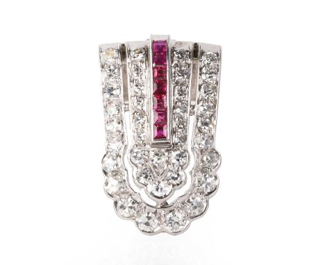 A diamond and ruby clip brooch, c.1940, with a central channel line of calibré cut rubies, within two tiers of graduated eigh