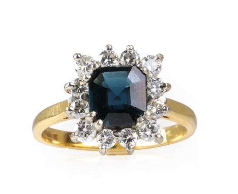 An 18ct gold sapphire and diamond cluster ring, with a central octagonal cut dark blue sapphire, claw set, surrounded by a ha