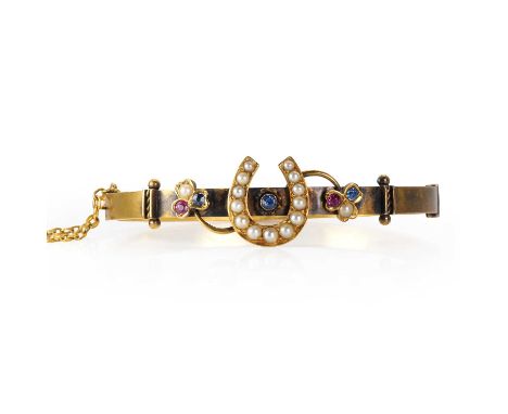 A late Victorian 15ct gold horseshoe bangle, the hollow hinged bangle with a central split pearl horseshoe motif enclosing a 