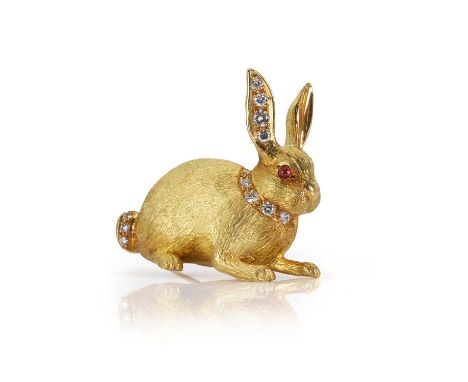 An 18ct gold ruby and diamond rabbit brooch,  the resting rabbit is accented with a line of graduated round brilliant cut dia