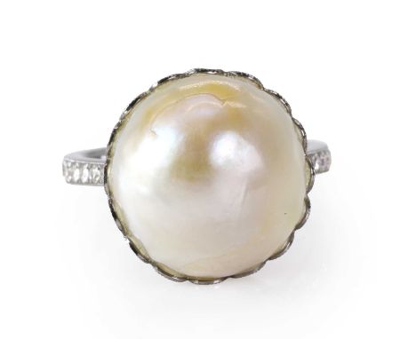 A large natural saltwater pearl ring with diamond set shoulders,  a natural button-shaped saltwater pearl, 14.03mm x 14.66mm,