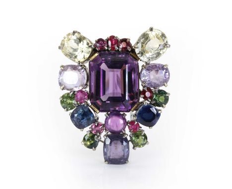 A varicoloured sapphire and amethyst clip brooch, c.1940-1950, of shield form, centring on a large step cut amethyst within a