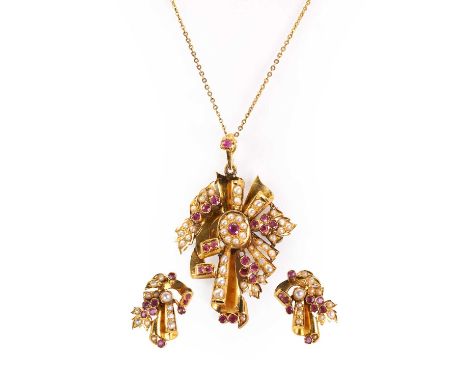 An Indian gold ruby and split pear pendant and earring set, c.1950, the pendant modelled as a stylised ribbon and spray, set 