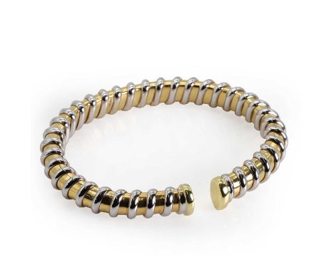 An 18ct bi-colour gold torque bangle, the sprung bangle of minimalistic woven design, set in white and yellow gold, with Ital