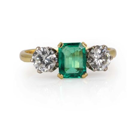 An 18ct gold Colombian emerald and diamond three stone ring,  centrally set with an octagonal step cut emerald, estimated as 