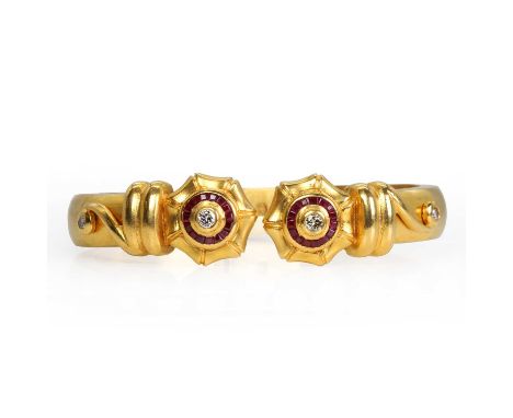 A ruby and diamond torque bangle, the hinged bangle with decorative detailing to each end, featuring four round brilliant cut