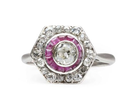 A diamond and ruby hexagonal target ring, c.1940,  an old cut diamond off-centrally set in a rub over collet, within a cresce