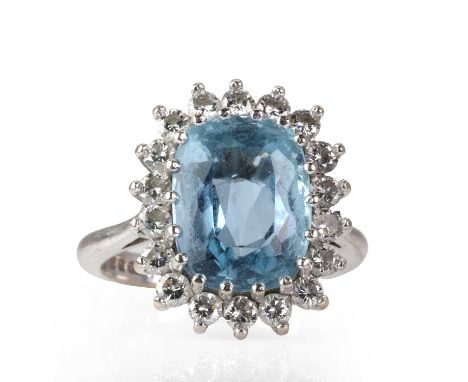 An 18ct white gold aquamarine and diamond cluster ring,  with a cushion cut aquamarine encircled by a surround or round brill