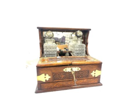 Antique brass bound mirror backed tantalus, missing one decanter, with a selection of vintage glasses, with key and drawer, m