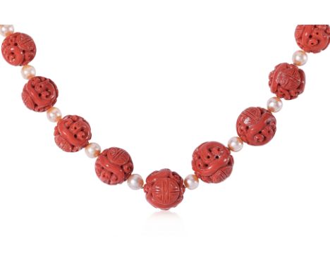 A LONG CARVED CORAL AND CULTURED PEARL NECKLACE Featuring graduated carved coral beads with the smallest measuring approximat