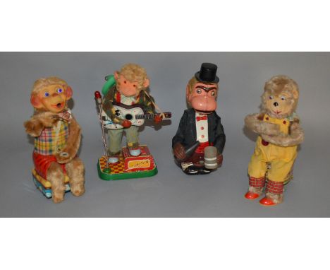 Four unboxed vintage battery operated tinplate toys including a Monkey Musician figure on tinplate 'stage' with guitar and mi