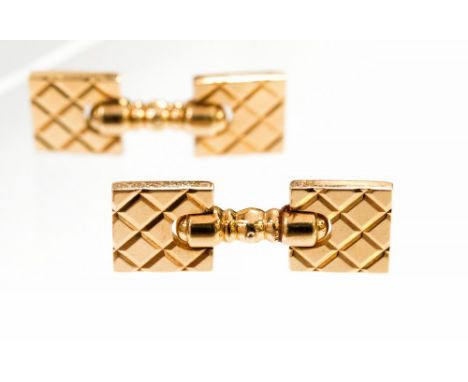 A pair of yellow gold cufflinks stamped 14K, the hinged action square plates with incised diaper pattern flanking turned balu