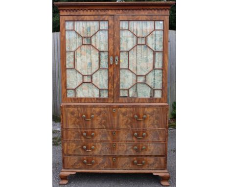 A George III mahogany secretaire linen press, the upper section with a fretwork geometric moulded edge and a repeated archite