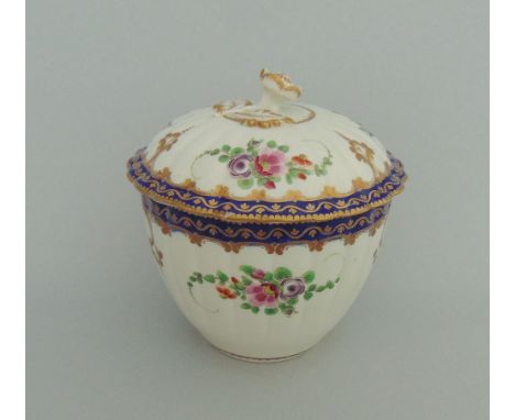 A Worcester sucrier and cover of fluted form, painted with flowers under blue and gilt borders, circa 1772-75, 10.5cm diamete