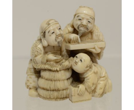 A Japanese ivory netsuke of two bearded gents and infant each a with soroban, Meiji period, 1868-1912, signed, width 3.5cmPed