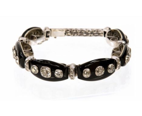 An Art Deco diamond and black onyx white gold bracelet, the six barrel shaped black onyx links each rub over set with three c
