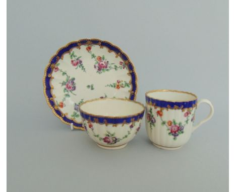 A Worcester trio of  reeded French shape, decorated with floral sprays and blue and gilt borders, circa 1780, crescent mark, 