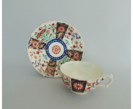 A Worcester fluted tea cup and saucer, decorated with 'The Queens' pattern, the cup with an elaborate handle, circa 1765, fre
