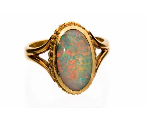 A black opal single stone 18ct yellow gold ring, the oval cabochon cut opal measuring approximately 13mm by 8mm, grey body co