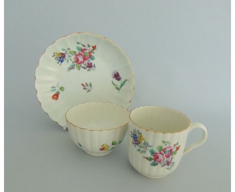 A Worcester trio, painted with flowers on a fluted body, circa 1775-78, tea bowl 7.8cm diameter, 5cm high, cup 6cm diameter, 