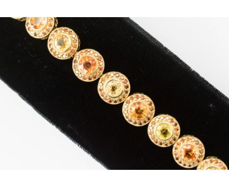 A yellow and orange sapphire and Cognac diamond bracelet, comprising 18ct gold round links, alternately set with a single ora