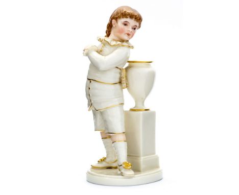 A Royal Worcester figure of a boy standing next to an urn, modelled by James Hadley, ivory glaze, highlighted in gilt with pa