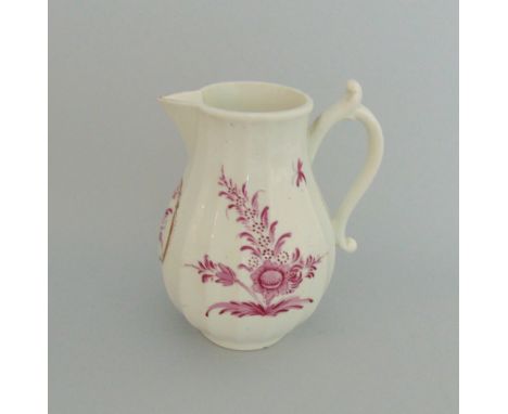 A Worcester faceted milk jug, puce painted flower sprays, one reserved in a gilt border, circa 1770, fret mark, 11cm highProv