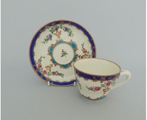 A Worcester Sevres style cup and saucer with an entwined handle, painted with flower sprays within turquoise, blue and gilt b