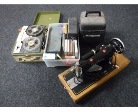 A cased vintage sewing machine, together with a Bell and Howell projector, a cased reel to reel and a box containing a pair o