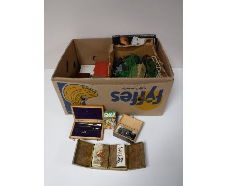 A box containing boxed playing cards, dominoes, game counters, model railway pieces, etc 