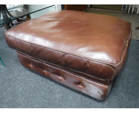 A brown button leather footstool