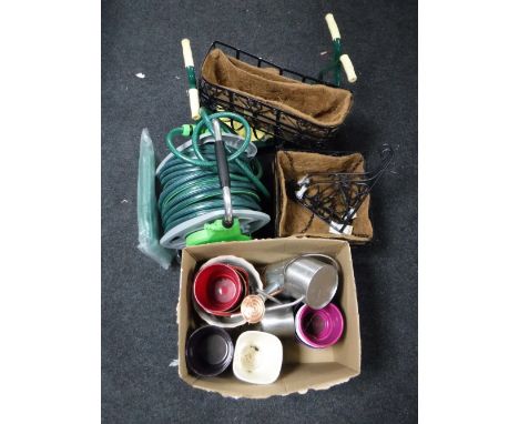 Several cast metal garden hanging baskets, hose pipe reel, planter, watering cans, etc 