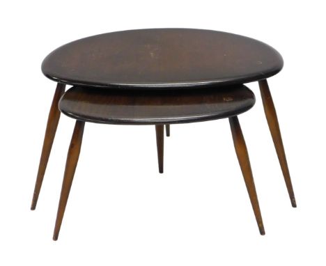 A nest of two Ercol dark stained oak pebble tables, the largest 62cm wide. 