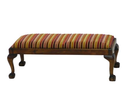 A mahogany fender stool, with striped padded seat, on cabriole legs with ball and claw feet, 84cm wide. 