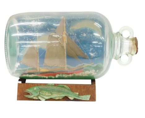 A scale model of a fishing vessel, in a glass demi john, on stand, demi john 31cm high.