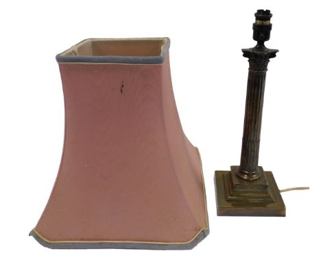 A 20thC metal table lamp base, of Corinthian column form on stepped base, with a pink shade, with pale blue trim, 70cm high.