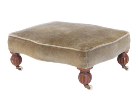 A Victorian walnut stool, with shaped padded top, on lobed bun feet and ceramic castors, 51cm wide. 