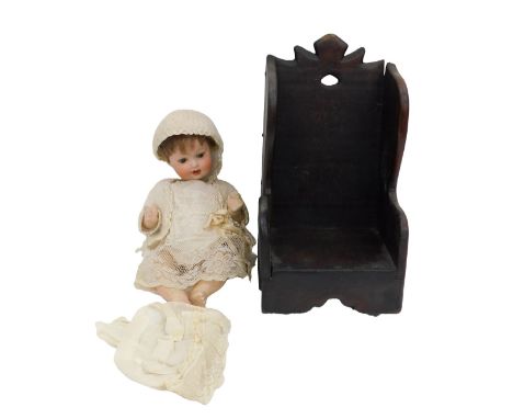 An Armand Marseille bisque doll, wearing a lace dress and knitted shrug and hat, numbered 914, impress marks, 29cm high, toge