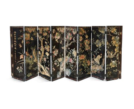 An eight panel lacquered screen, Qing period, of carved gesso decoration with fanciful birds amongst pomegranates125 x 305cmL