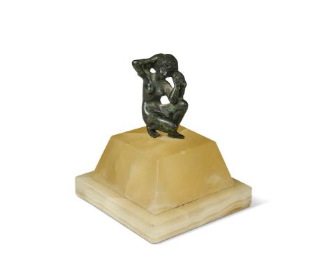 A Roman bronze statue of a woman, the female nude modelled in a crouching position and mounted to a later onyx base10cm high 